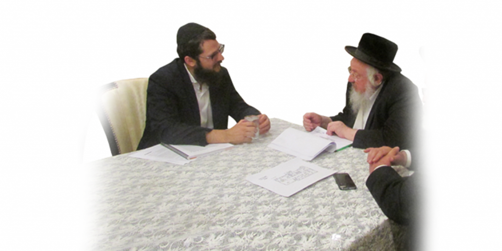 Discussing a mikvah project with the Rav across a table